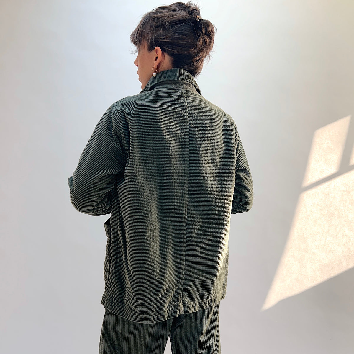 Angled back view of the Lux Corduroy Long Blazer in Kelp, showing the collar, corduroy texture, and center-back seam.
