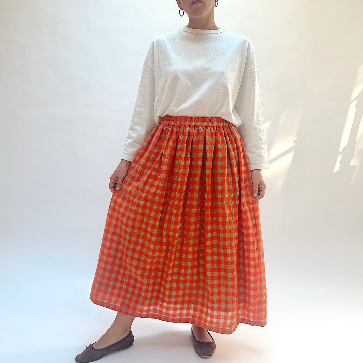 Ichi Antiquités Gingham Wool Check Skirt in Beige & Orange, front view with model holding the sides out.
