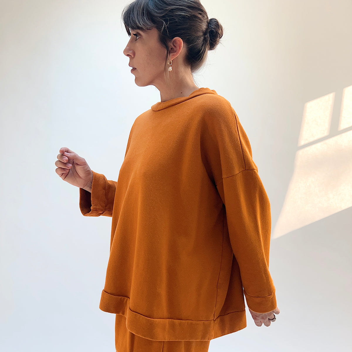 Side view of Alden Fleece Sweatshirt in Yera on a model, showing the loose drape and banded hem.
