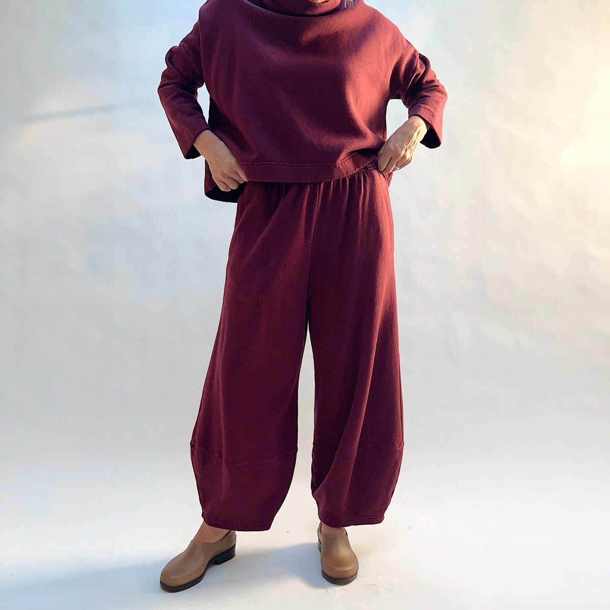 Front view of Oliver Fleece Pant in Rhone with the sweatshirt lifted to show the gathered elastic waistband.
