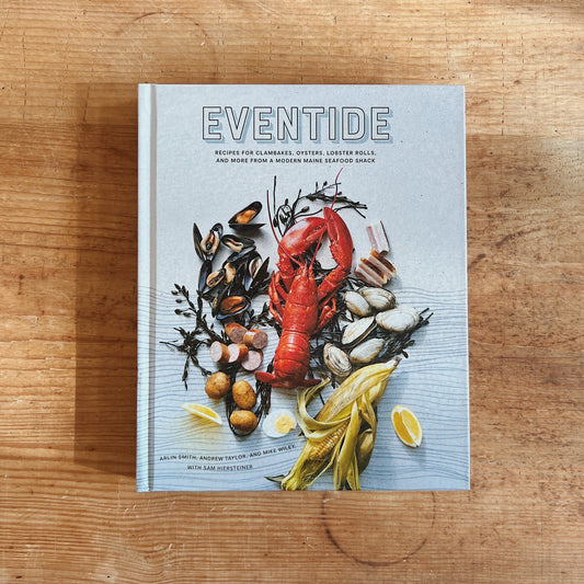 Front cover of Eventide cookbook, featuring lobster, shellfish, corn, potatoes, and lemon, on a wooden surface.
