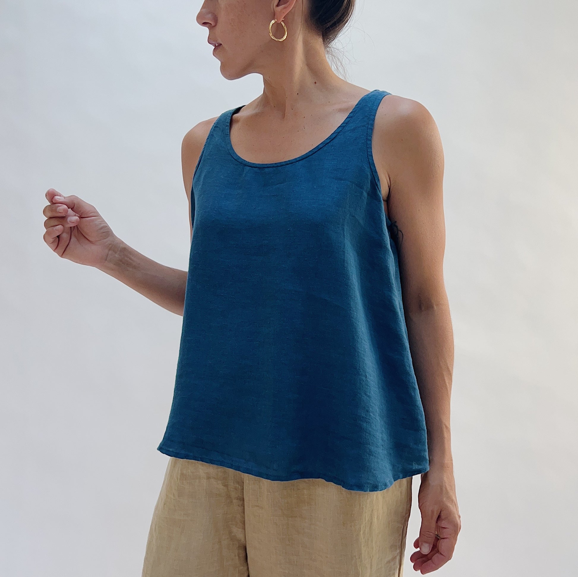 Front view of the Basic Tank in French Navy by Yuvita — a cropped 100% linen scoop-neck tank in deep teal blue, styled with tan linen trousers on a white background