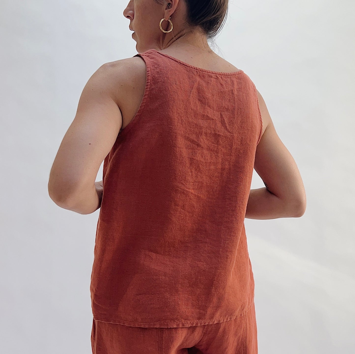 Back view of the Basic Tank in Terracotta by Yuvita, showing the clean linen back, wide straps, and scoop back neckline in warm terracotta, styled with matching terracotta linen pants