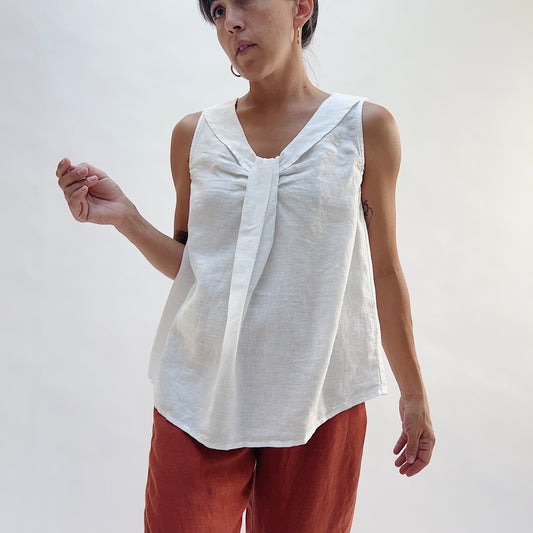 Front view of the Sailor Tank in White by Yuvita, showing the V-neckline with gathered twist detail, sailor collar, and relaxed linen silhouette in white, styled with terracotta linen wide-leg pants
