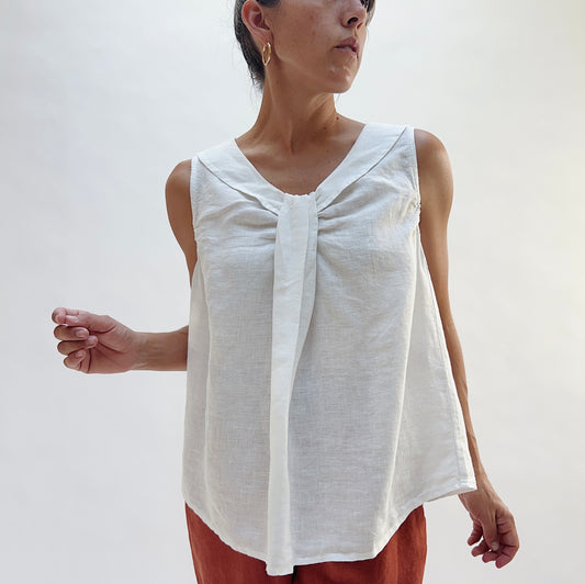 Close-up front view of the Sailor Tank in White by Yuvita, highlighting the gathered twist neckline, sailor collar, and relaxed A-line drape in white linen, styled with terracotta linen pants