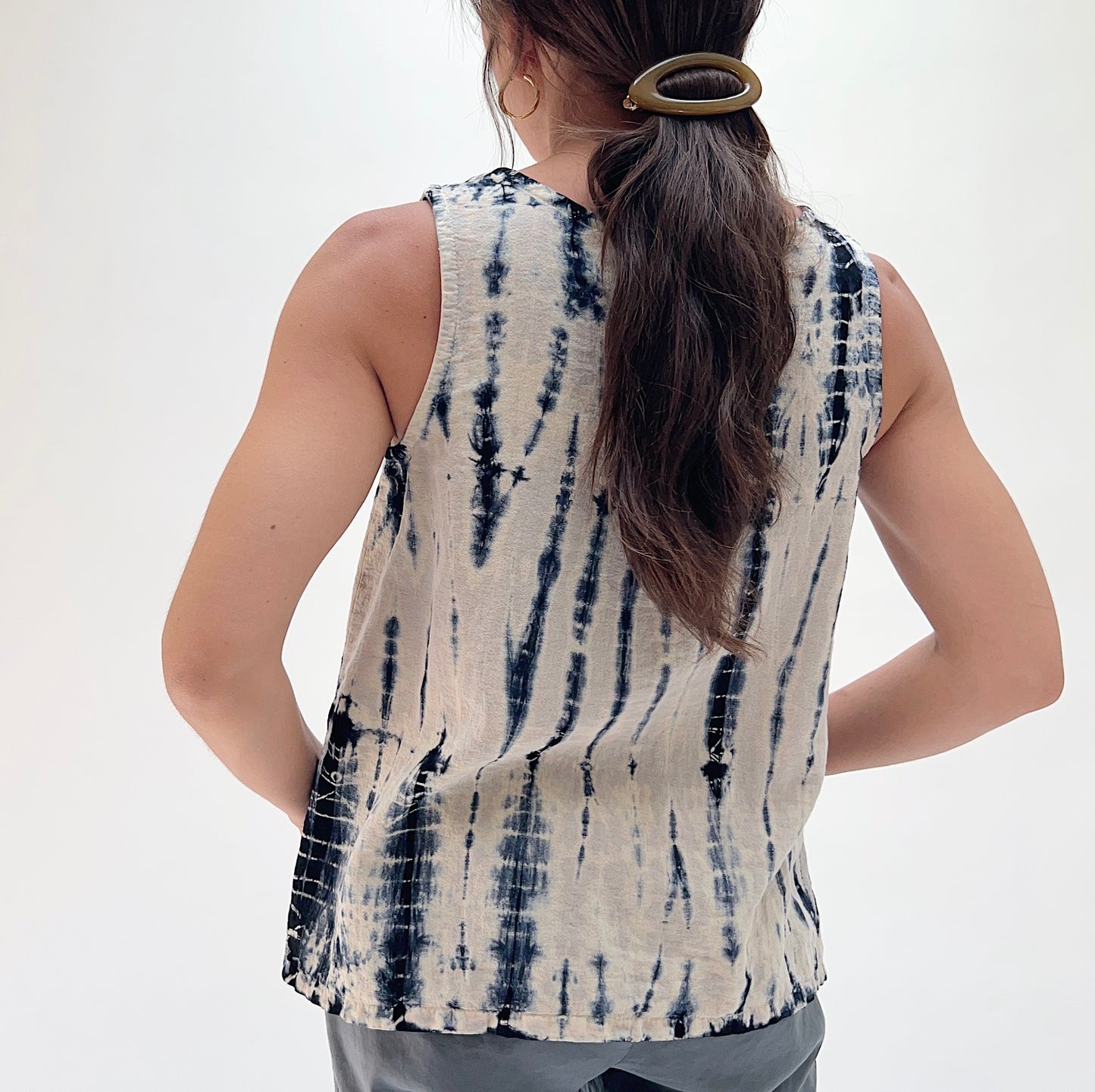 Back view of model wearing Eleven Stitch Crinkle Travel Gail Tank in indigo tie-dye, showing open back and crinkle fabric detail 