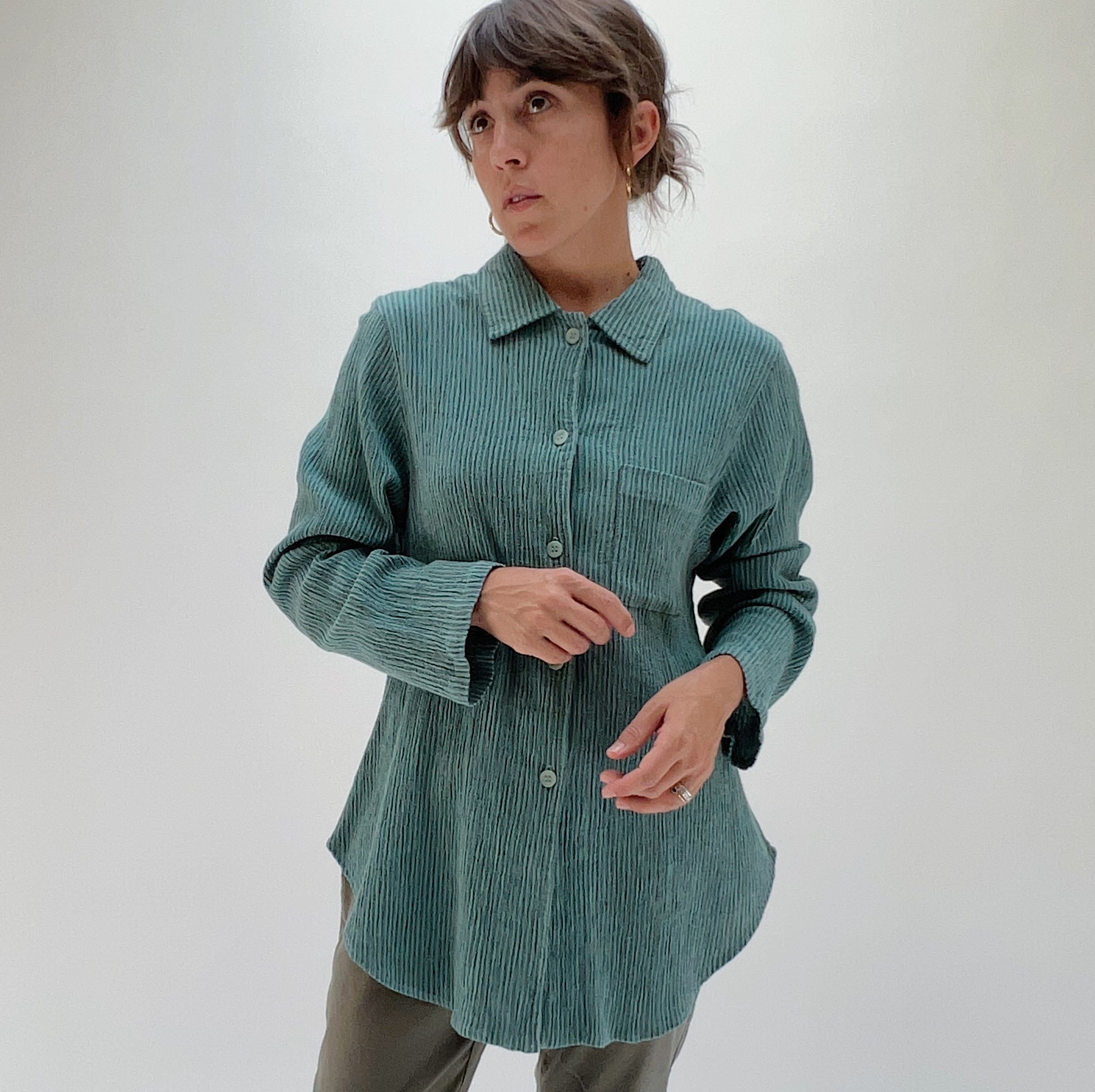 Front three-quarter view of model wearing Mill Valley Clothing Co blue sage boyfriend button-down shirt, showing point collar, chest pocket, and relaxed oversized fit