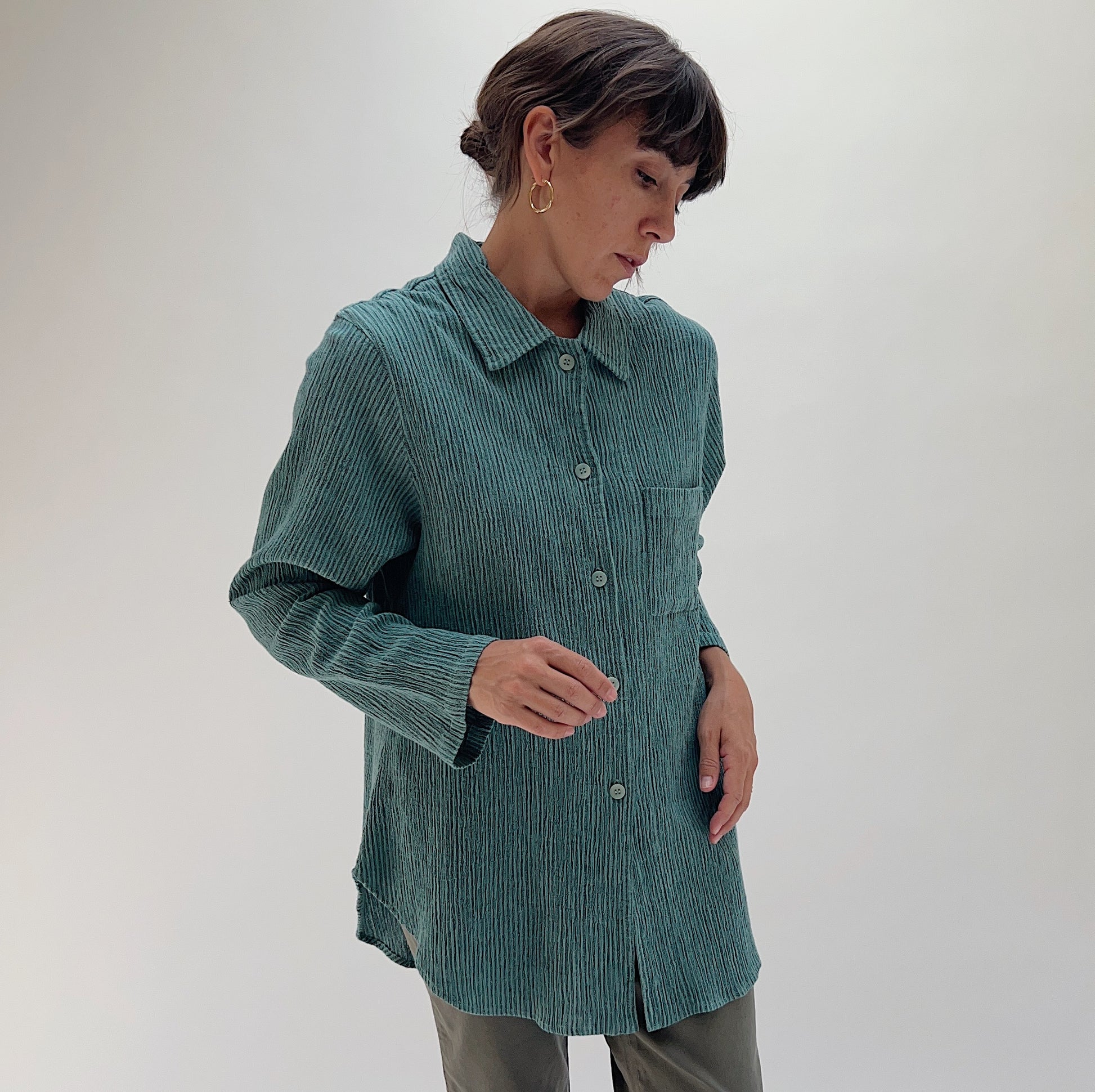 Full front view of model wearing Mill Valley Clothing Co blue sage crinkle button-down shirt, showing tunic length, button placket, and curved hem