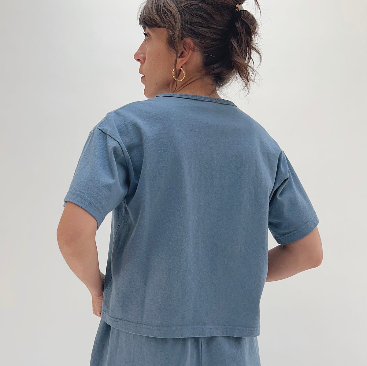 Back view of model wearing Pacific Cotton vitznau crop crew tee, showing boxy silhouette, short sleeves, and straight cropped hem