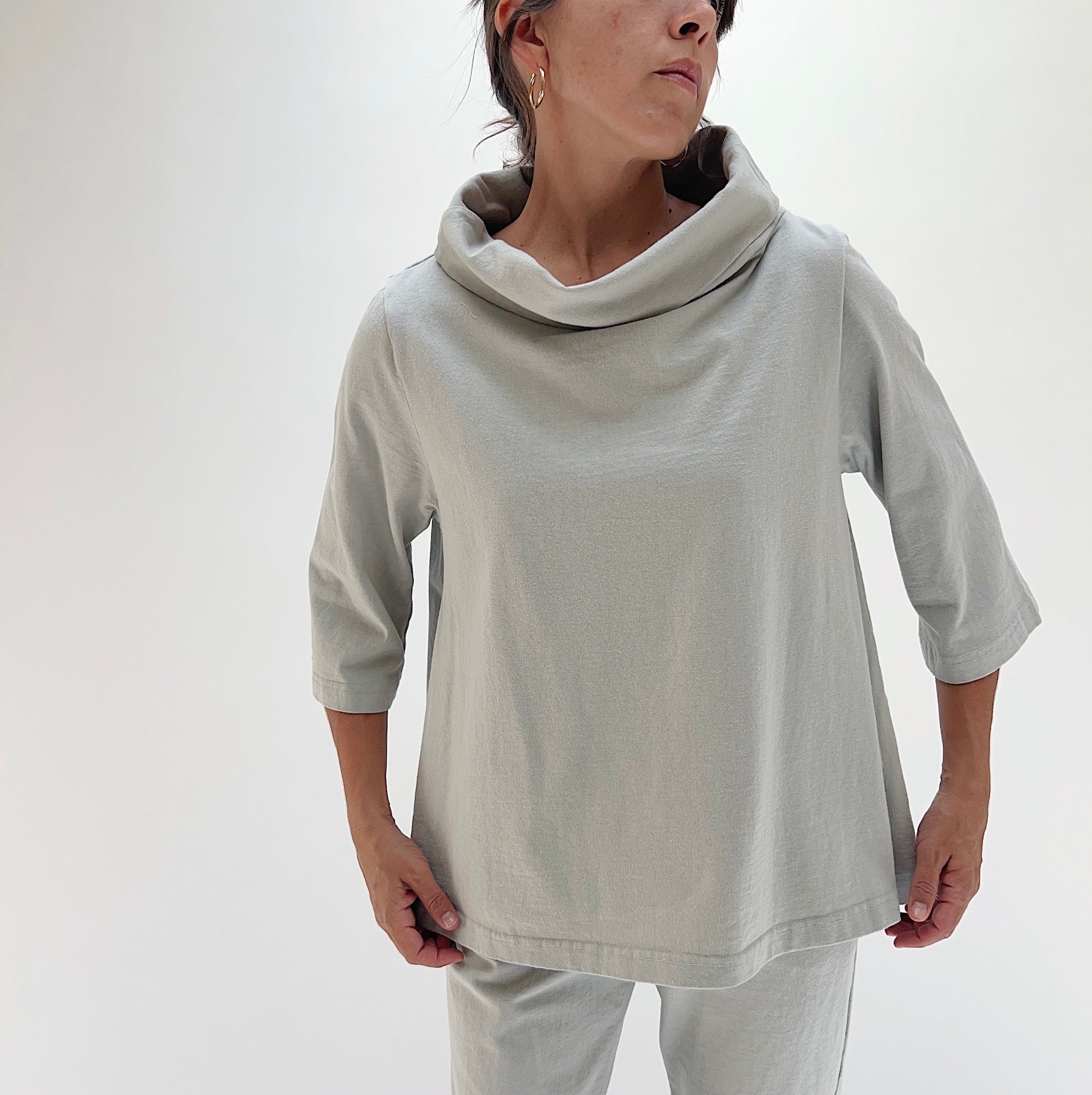 Close front view of model wearing Bryn Walker orlaya 3/4 sleeve Etta top, showing draped cowl neckline detail, boxy fit, 3/4 sleeves, and banded hem