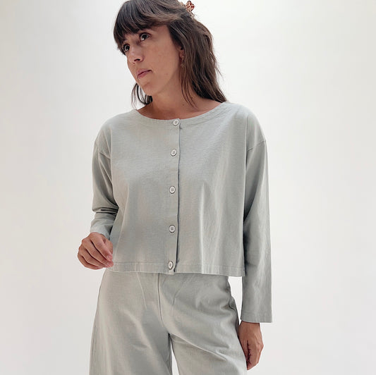 Full front view of model wearing Pacific Cotton orlaya long sleeve button front shirt, showing crew neckline, five-button center placket, long sleeves, and cropped boxy fit