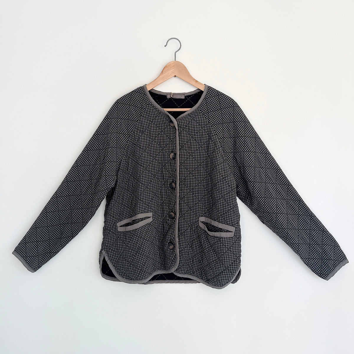 Cut Loose Easy Jacket in Iron Mini Check, front view on a hanger showing the button front, gray trim, and two patch pockets.
