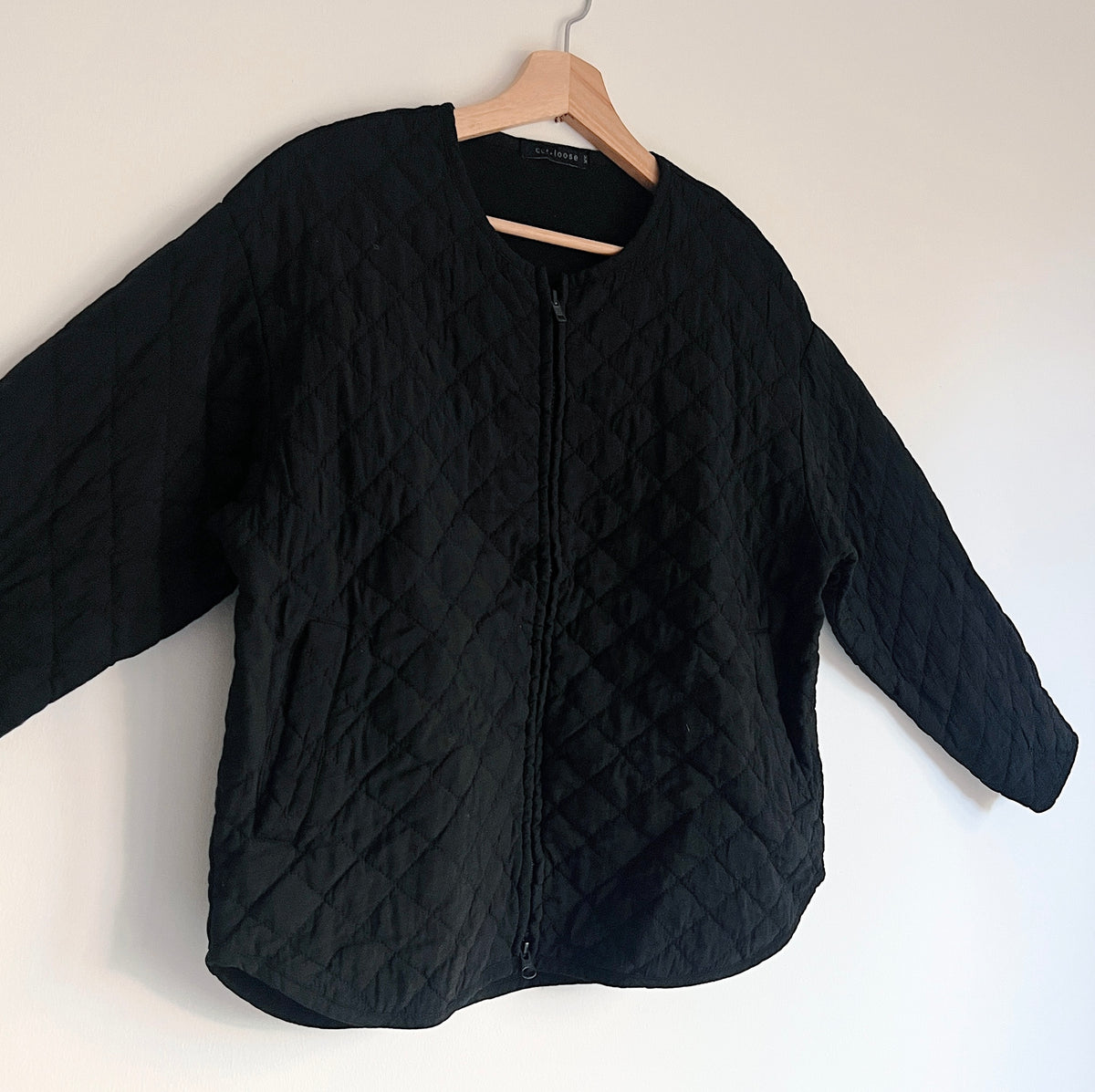 Cut Loose Quilted Bomber Jacket in Black, close angled front view showing diamond quilting and the front zipper.
