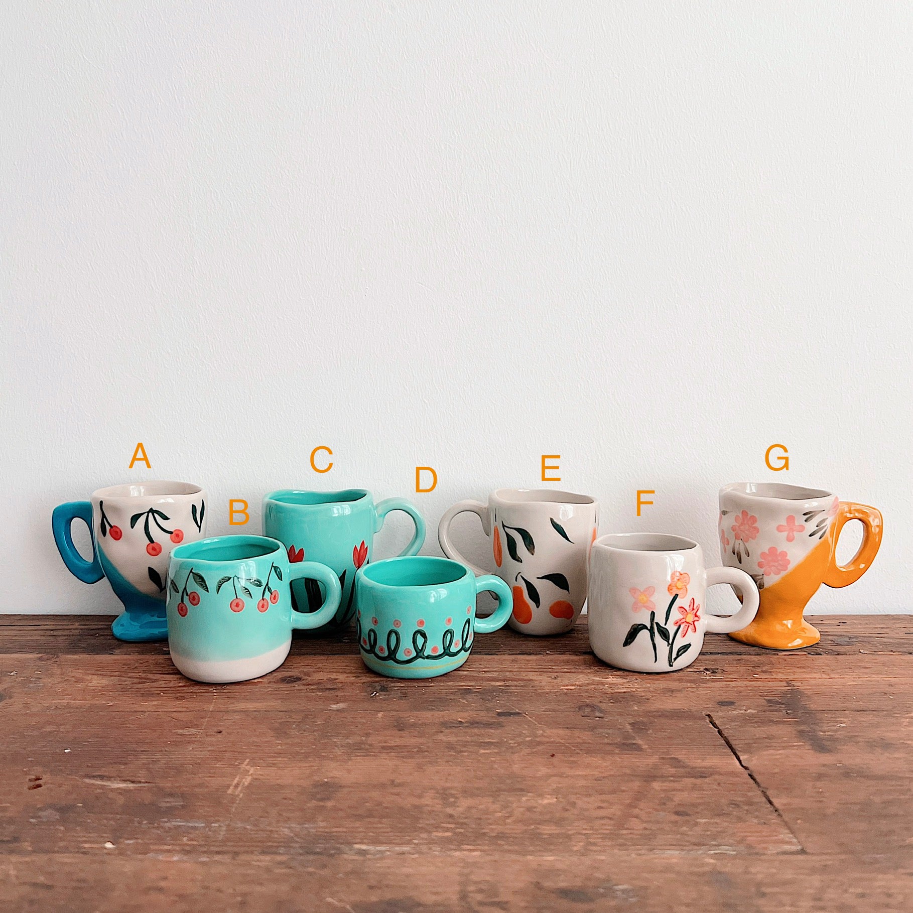 Mug selection guide: A, blue-footed cherries; B, turquoise cherries; C, turquoise tulips; D, turquoise loops; E, cream fruit; F, cream flowers; G, yellow-footed flowers.
