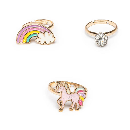 Three rings with unicorn, rainbow, and crystal designs on a white background