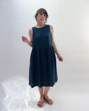 Load image into Gallery viewer, Woman wearing a dark blue sleeveless dress against a white background
