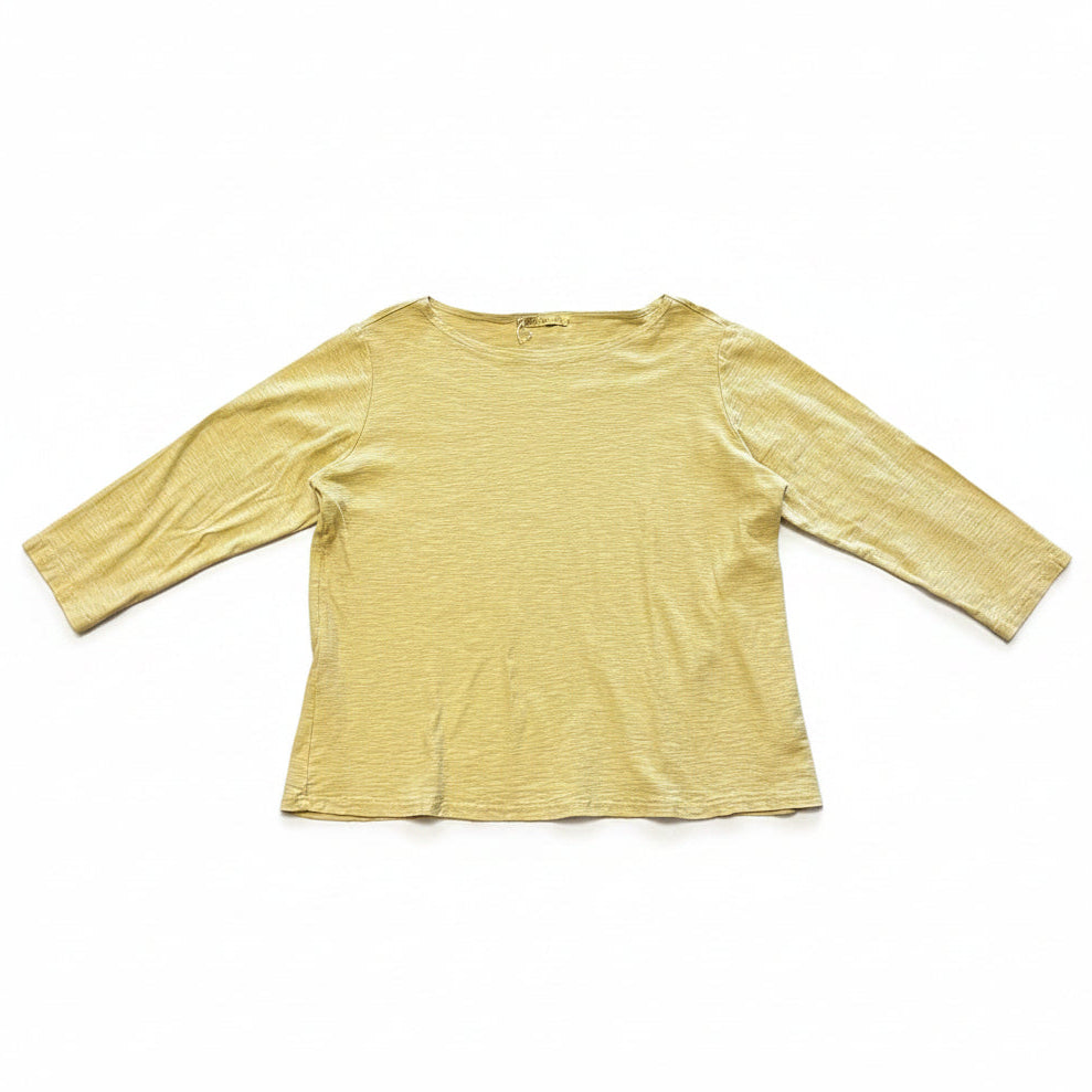 Yellow long-sleeve shirt on a gray concrete floor