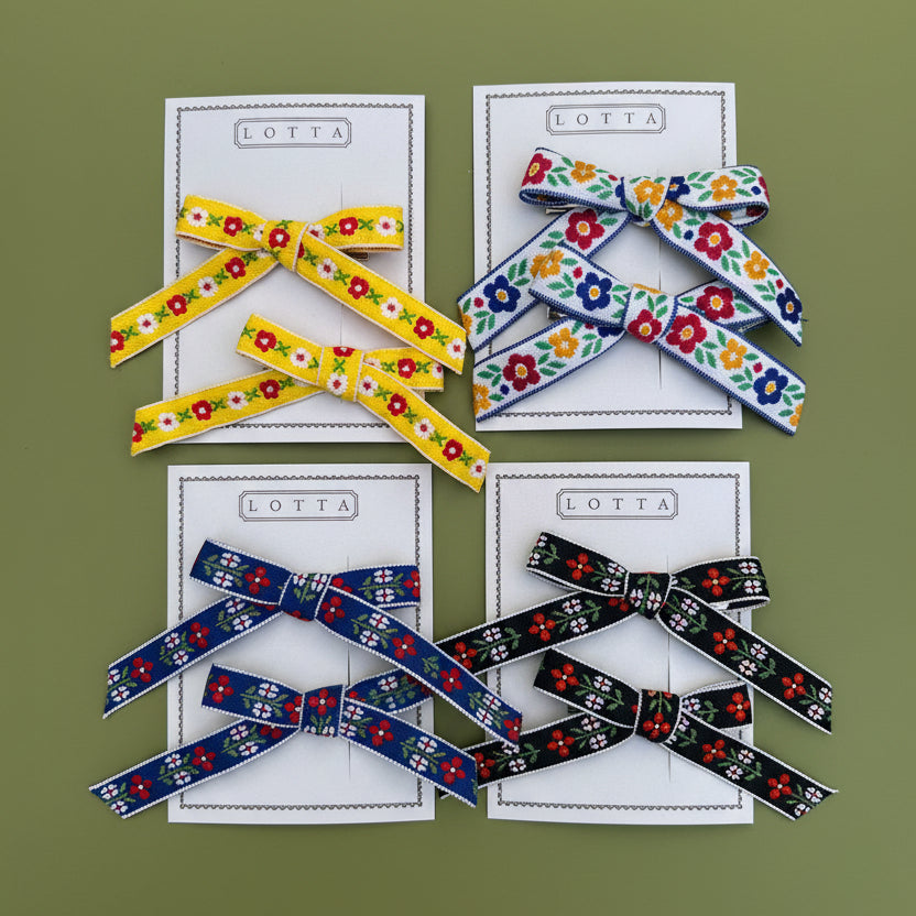 Colorful ribbon bows on a light green card with text that says, "Lotta".