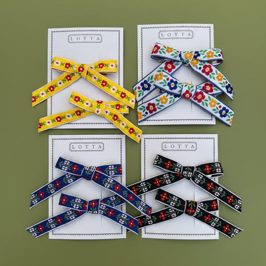 Colorful ribbon bows on a light green card with text that says, "Lotta".