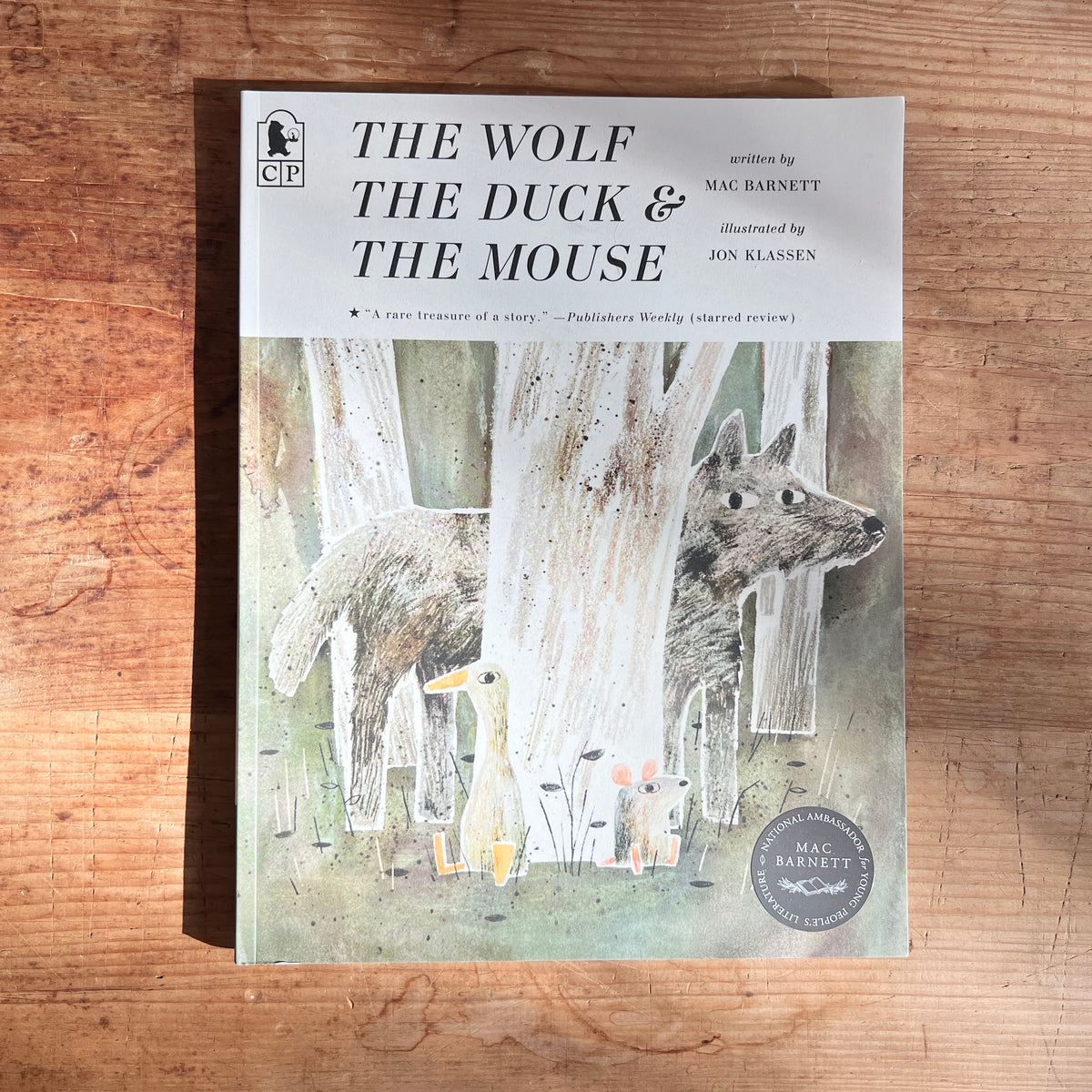 Paperback cover of The Wolf, the Duck, and the Mouse by Mac Barnett, illustrated by Jon Klassen, showing the three animals among pale tree trunks.
