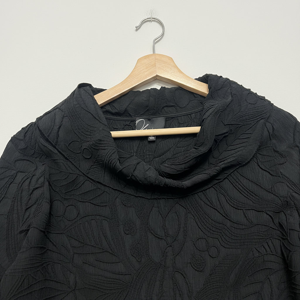 Black textured blouse on a wooden hanger against a white background