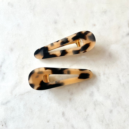 Two tortoiseshell hair clips on a white background