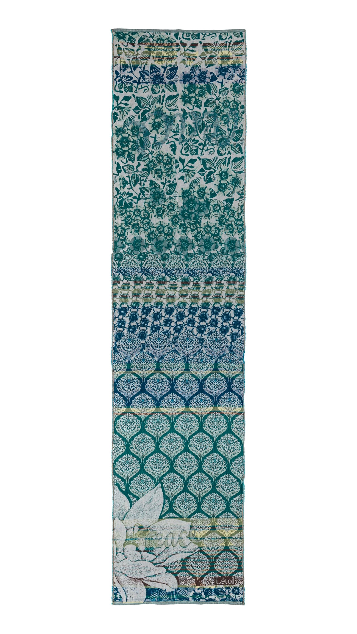 Létol Louise Scarf in Cedar Teal, laid flat and fully extended against a white background, showing the full length of the scarf with a dramatic gradient composition — the top third in a dense teal floral and bird print on a light ground, transitioning through a blue-teal geometric chrysanthemum band, then a deeper indigo ogee lattice zone with tree-of-life fills, deepening into a rich dark teal ogee pattern at the base with a large Jacquard-woven magnolia motif and the Létol signature in the lower corner
