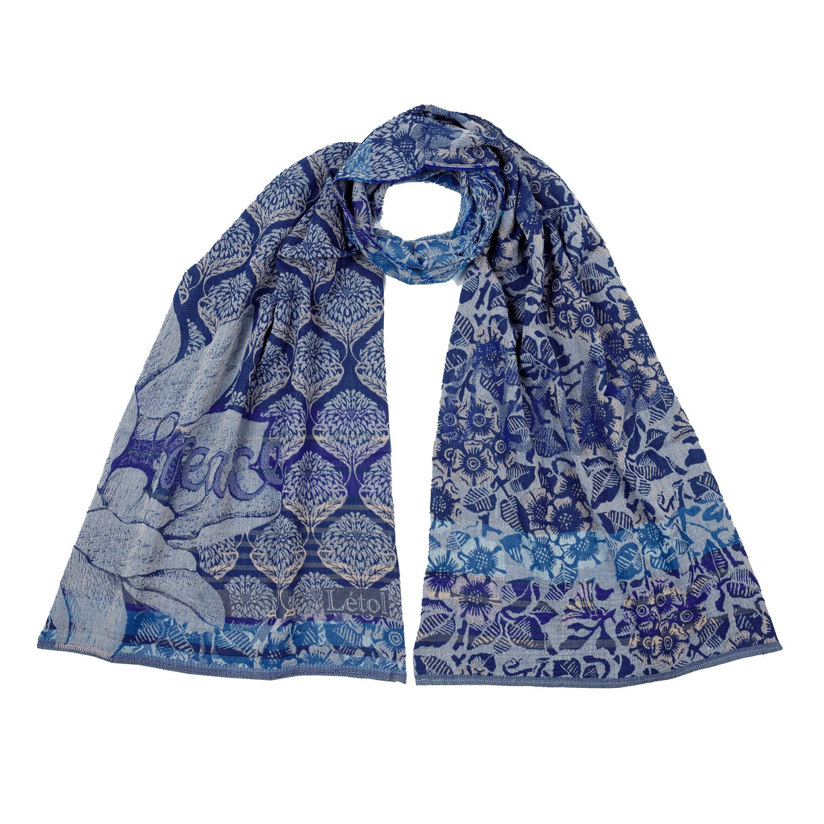 Létol Louise Scarf in Crépuscule Night Blue, looped and laid flat against a white background showing both sides simultaneously — one side featuring a bold indigo and light blue ogee lattice filled with Mughal tree-of-life motifs and a large botanical rose in the lower corner with the woven Létol signature, the other showing a dense all-over indigo floral and bird print on a light blue ground with sunflower, chrysanthemum, and fauna motifs
