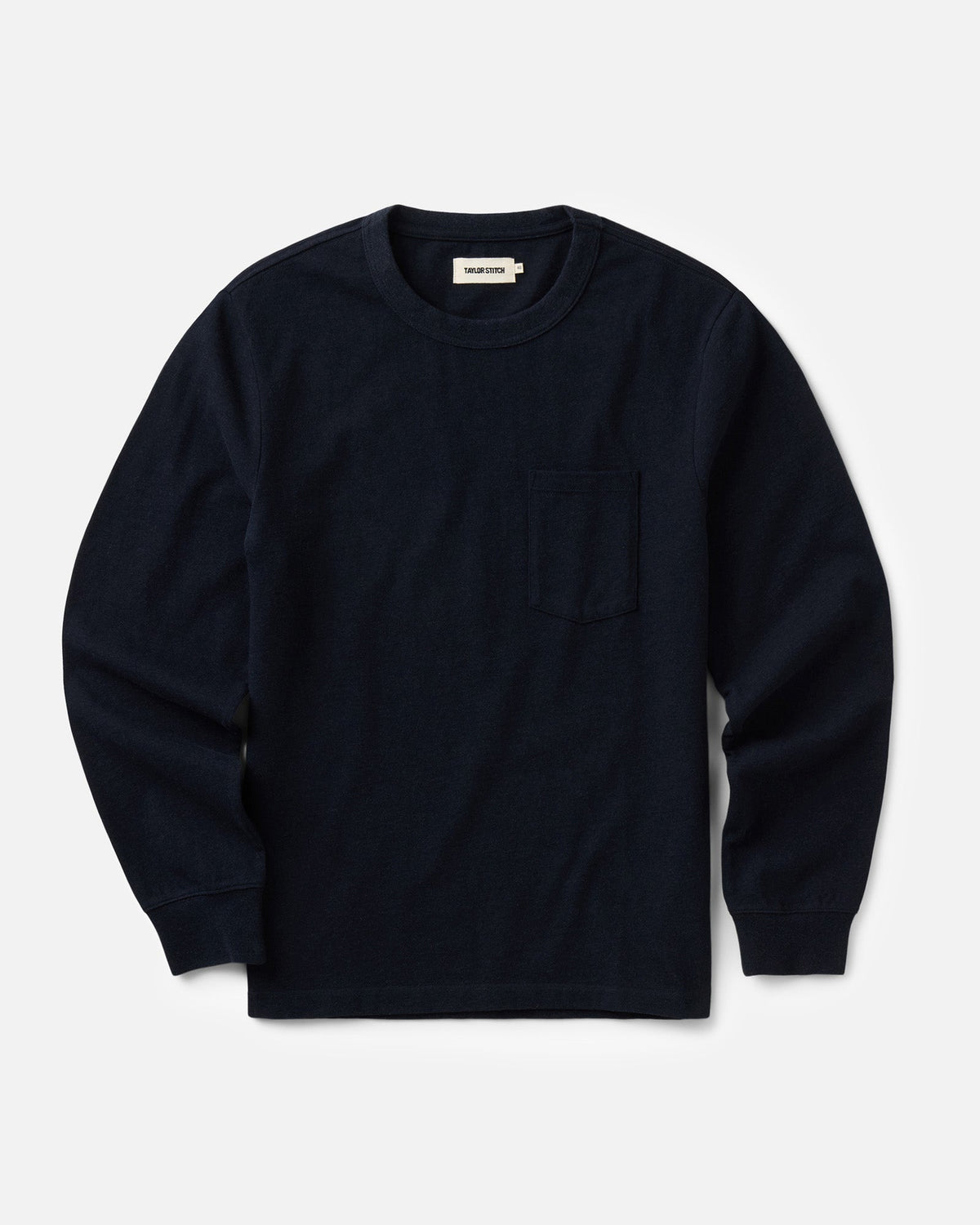 Flat lay view of Taylor Stitch’s Long Sleeve Shop Tee in Navy Twist, showing the crew neckline, single chest pocket, and long sleeves with cuffs.

