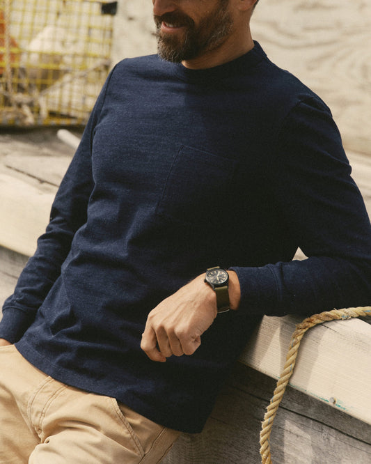 Front view on a model of Taylor Stitch’s Long Sleeve Shop Tee in Navy Twist, showing the crew neckline, chest pocket, and cuffed sleeves.
