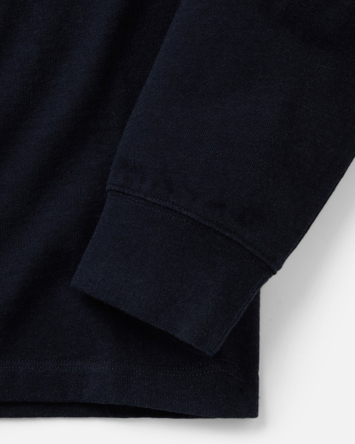 Close-up of the Long Sleeve Shop Tee in Navy Twist, showing the sleeve cuff and stitched bottom hem.

