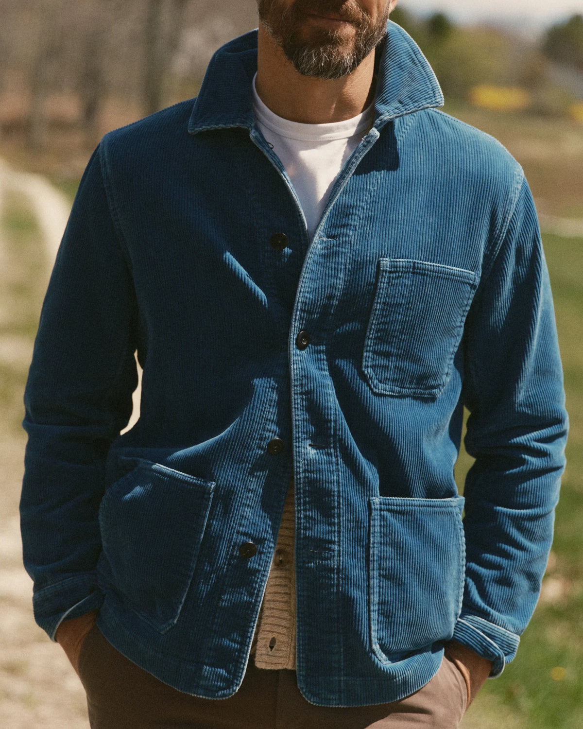 Front view on a model of the Ojai Jacket in Washed Indigo Corduroy, worn over a white shirt with the collar turned up.
