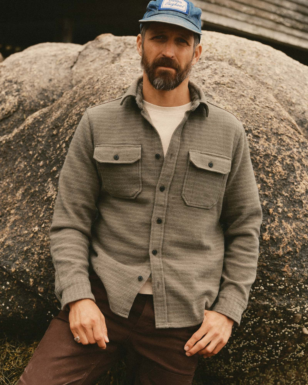 Model wearing Taylor Stitch’s Division Shirt in Cypress over a white T-shirt, showing the textured fabric and flap chest pockets.
