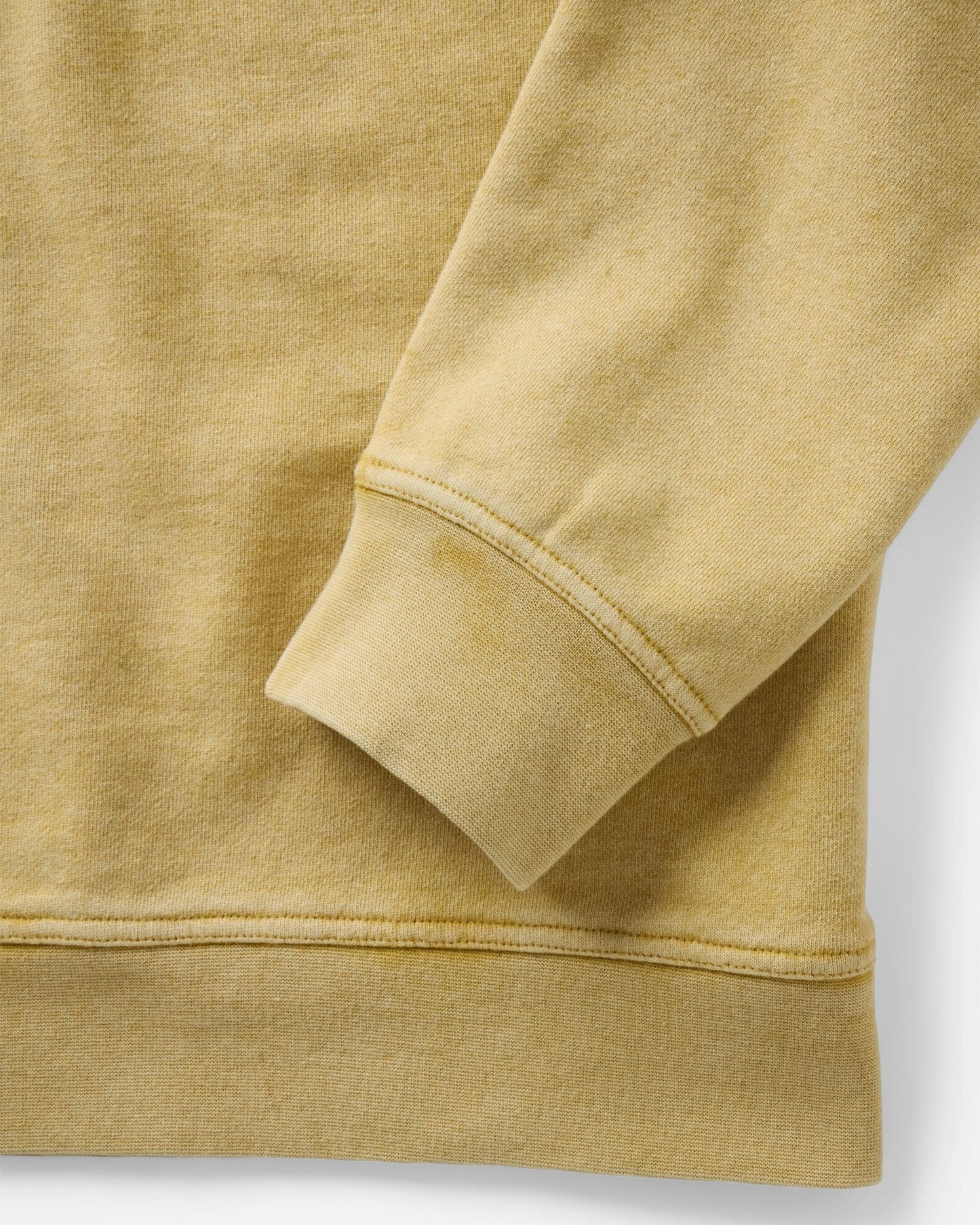 Close-up detail of the Taylor Stitch Sunset Henley sleeve cuff and hem, showing heavyweight ribbing and sun-faded goldfinch yellow French terry fabric