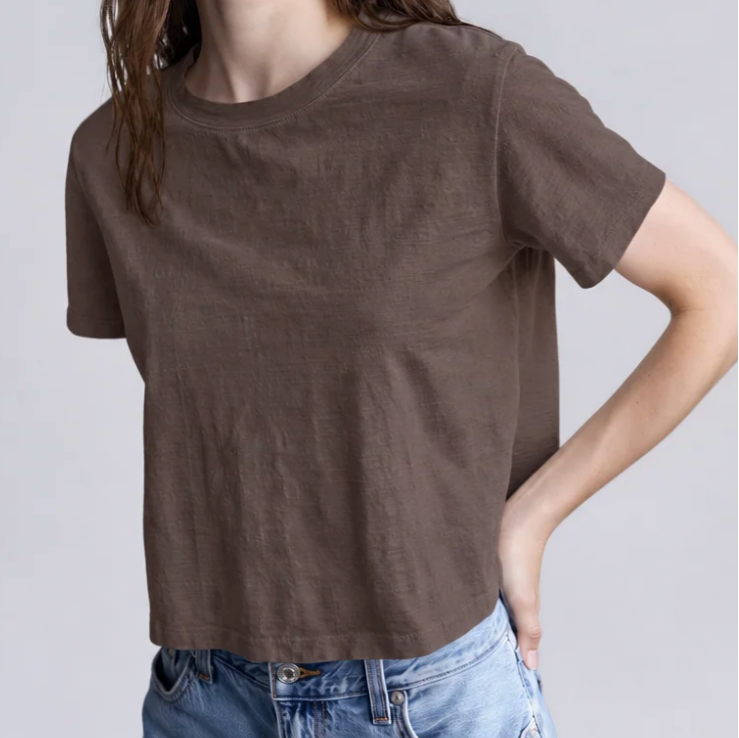 Model wearing a chocolate brown boxy cotton crop tee with a round neckline and short sleeves, paired with jeans.
