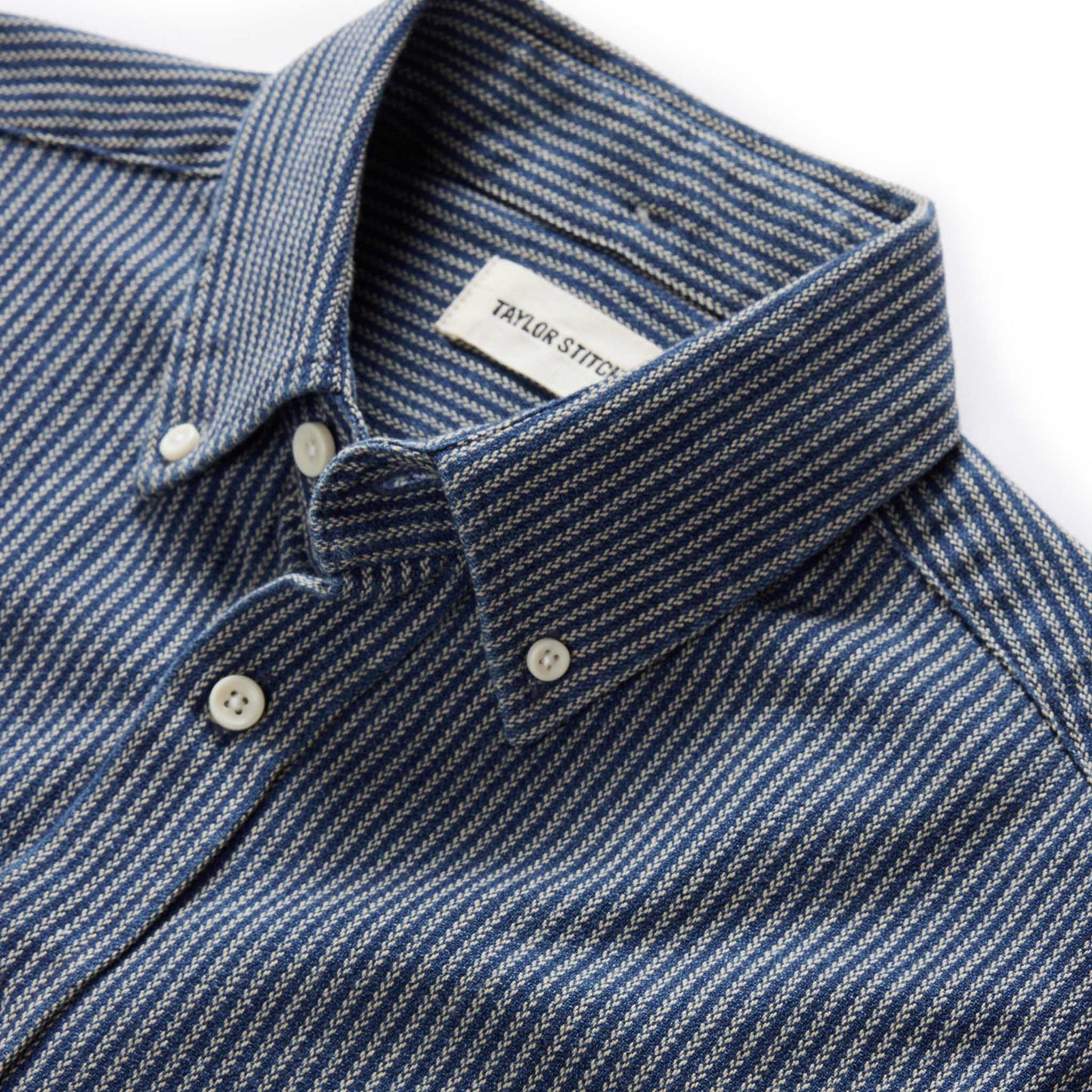 Close-up of the collar and button-down placket on The Jack in Roped Indigo by Taylor Stitch, showing the Taylor Stitch label and roped indigo fabric texture