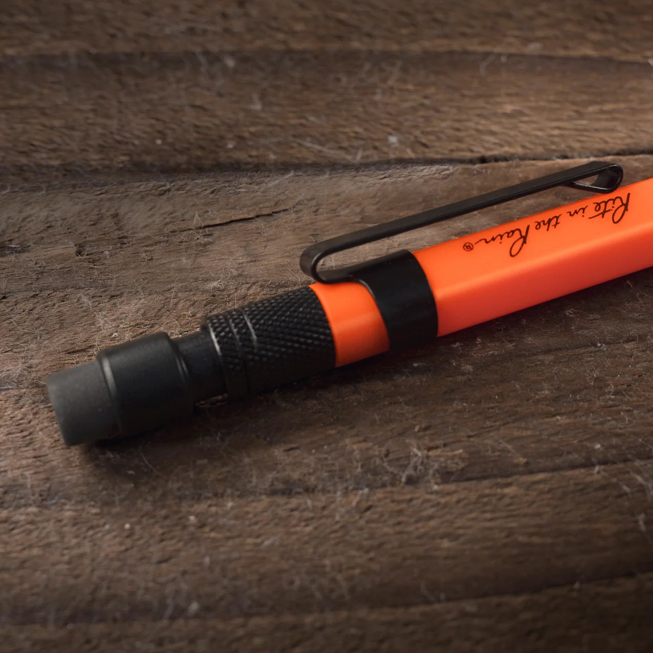Orange and black pen on a wooden surface