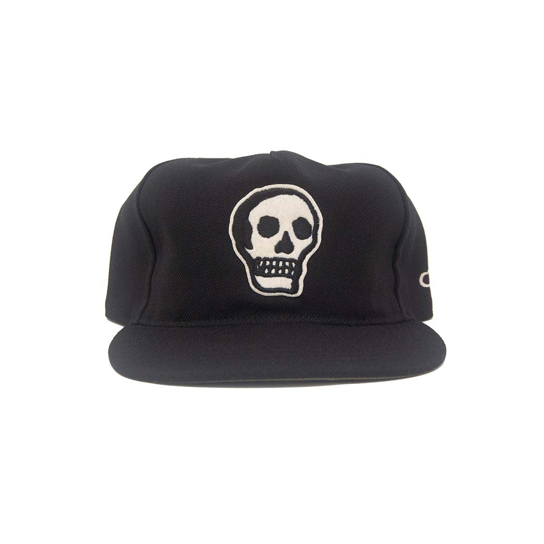 Front view of the Ampal Creative Skull II Black Snapback, featuring a large embroidered white skull with black outline on the front panel and Ampal script logo on the side, on a black poly upper with flat brim, on a white background
