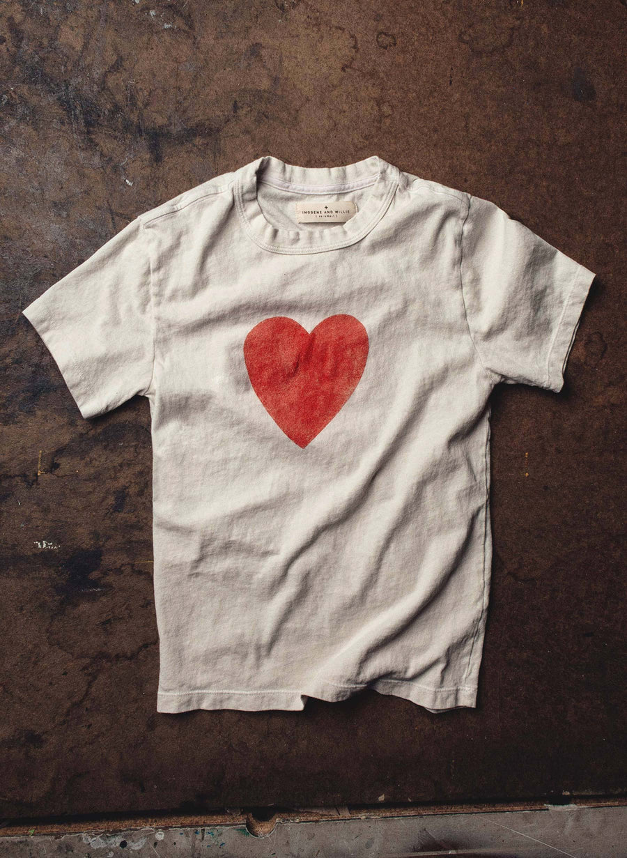Flat lay on dark concrete showing full front with large red heart print and Imogene + Willie label