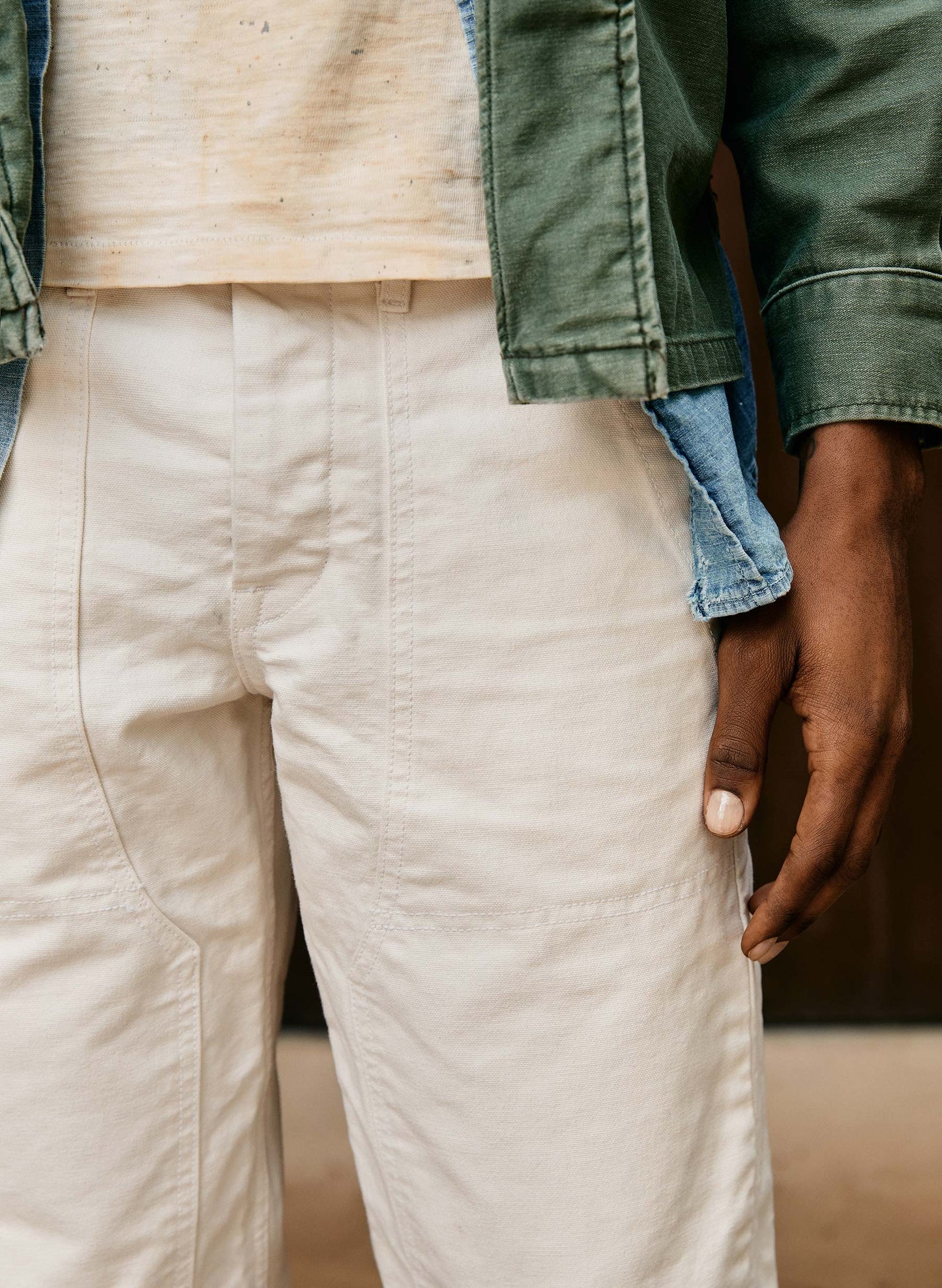 Close-up of the front rise and side pocket of the Hencye Canvas Workpant in Natural, showing the mid-rise fit, patch pocket detail, and natural off-white canvas fabric texture
