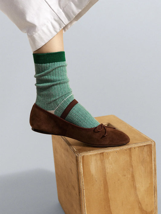 Multi Stripe Hiker Crew socks in Green — green micro-stripe cotton hiker crew with bold green ribbed cuff, worn slouched with brown suede bow ballet flats under white wide-leg trousers on a grey background
