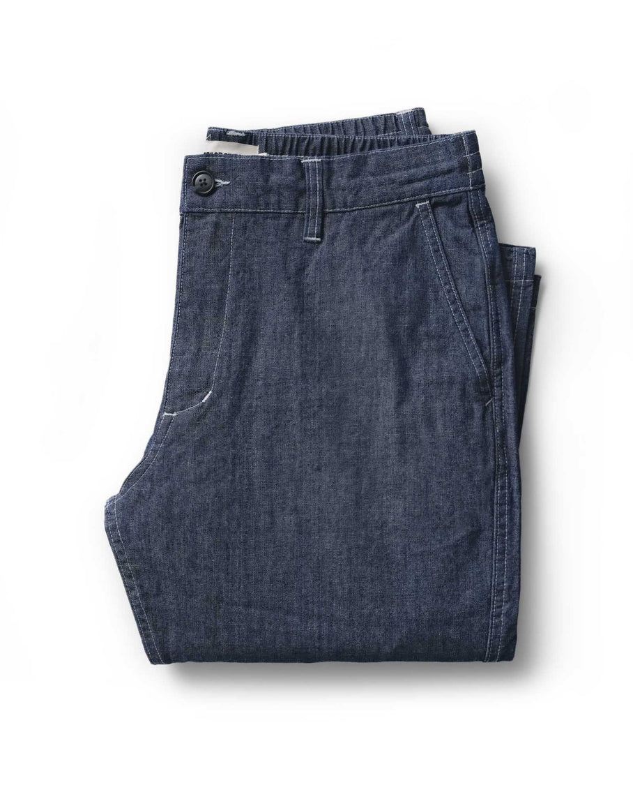 Folded dark blue jeans on a white background
