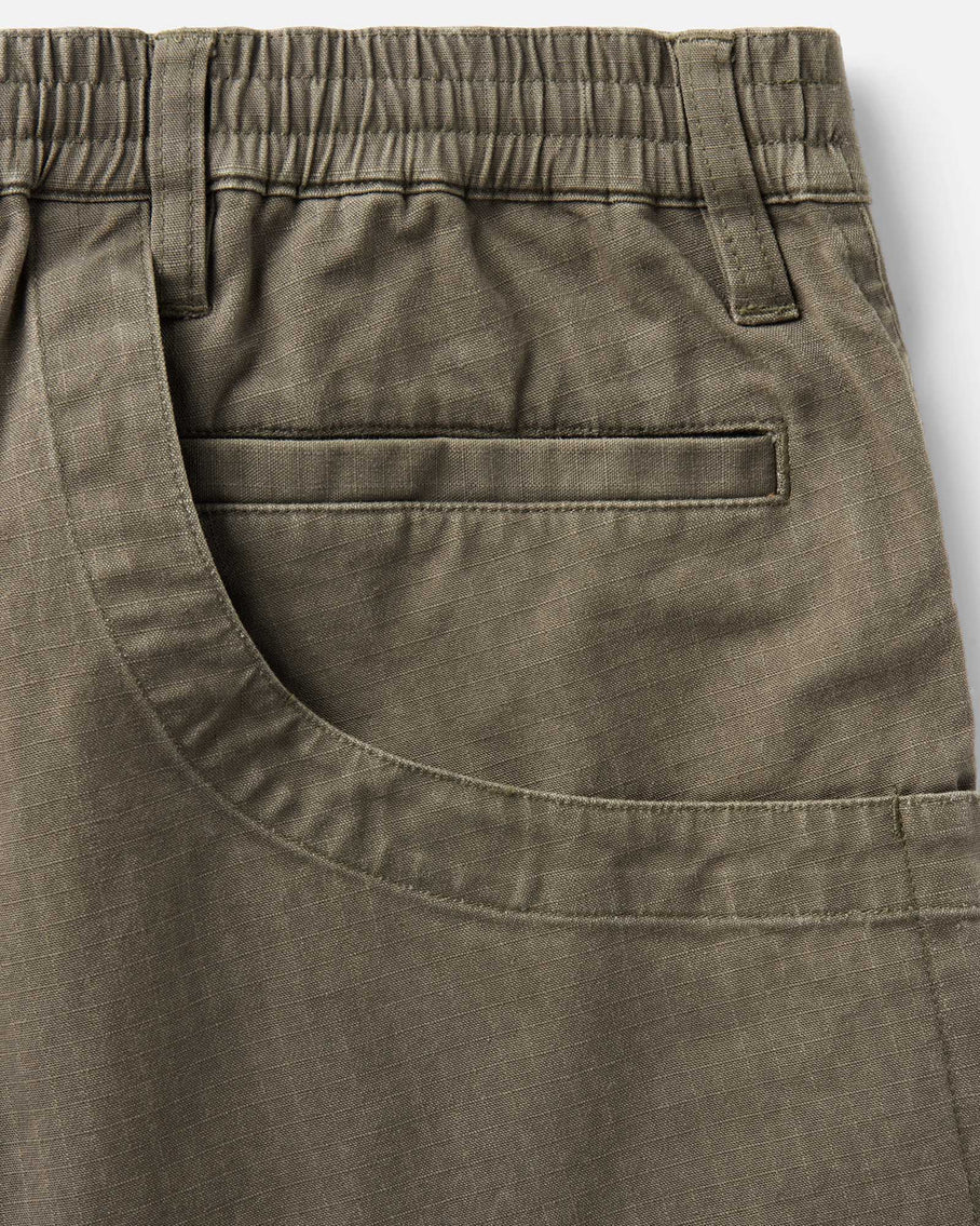 Close-up of olive green shorts with a pocket on a white background