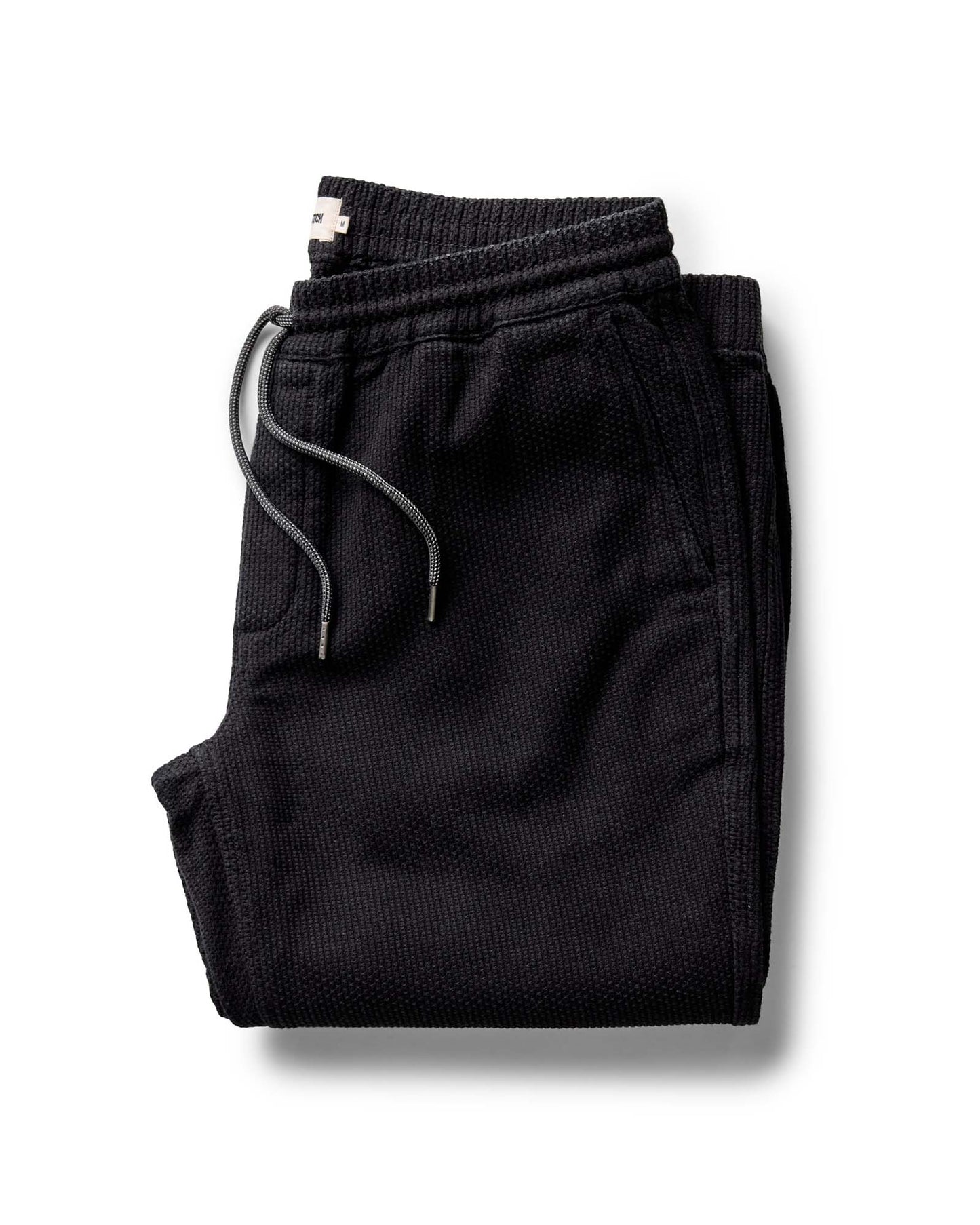 Folded black pants on a white background