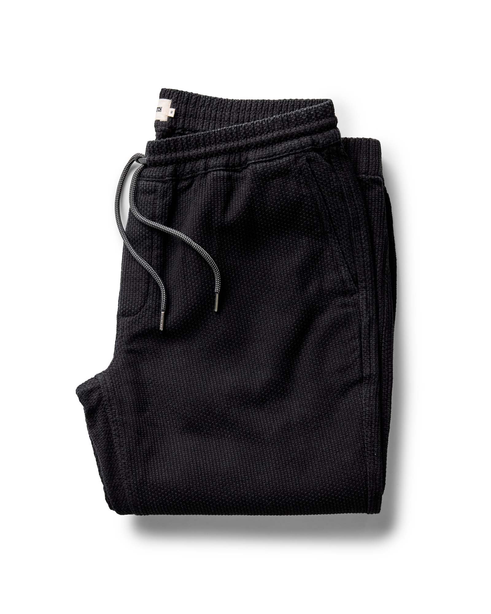 Folded black pants on a white background