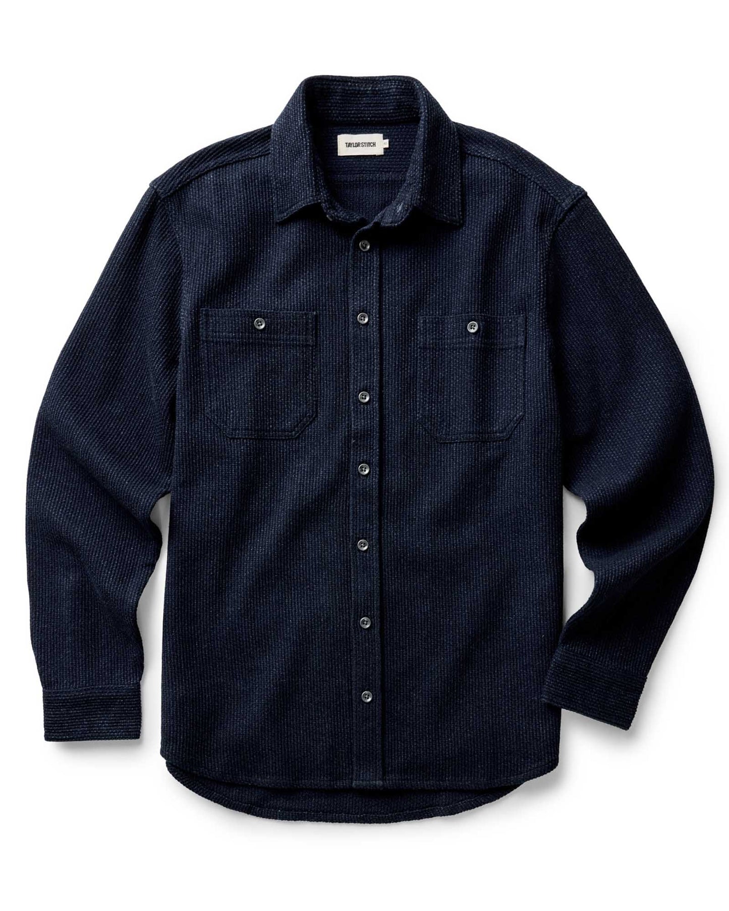 Taylor Stitch Utility Shirt in Rinsed Indigo Sashiko folded flat, front view showing deep rinsed indigo organic cotton sashiko weave texture, spread collar, and dual button-through chest pockets
