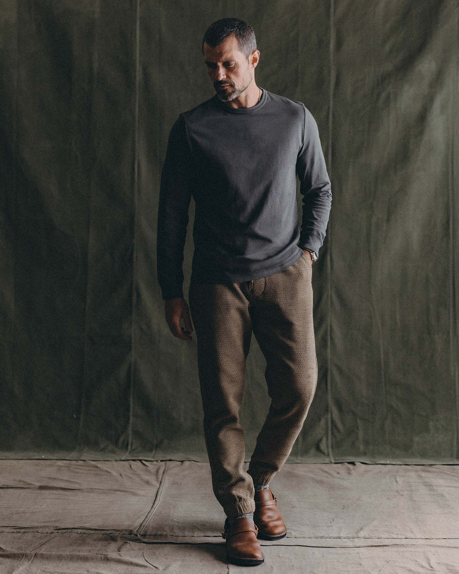 Model wearing Taylor Stitch Après Ski Pant in Cypress Sashiko with a dark grey long-sleeve top and brown leather shoes, full-length editorial shot

