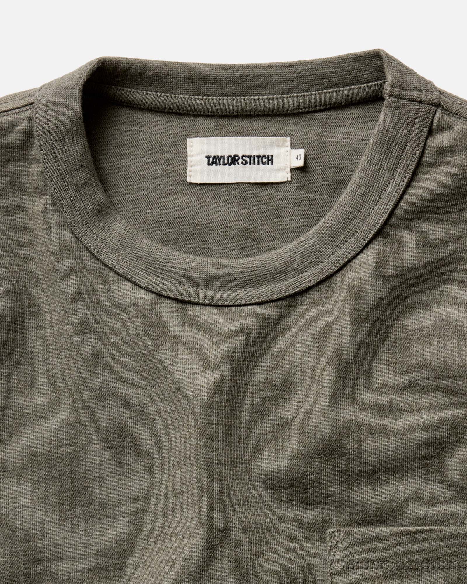 Close-up of the crew neck and Taylor Stitch label on The Long Sleeve Shop Tee in Army Twist, showing the 1x1 ribbed collar and army twist cotton texture