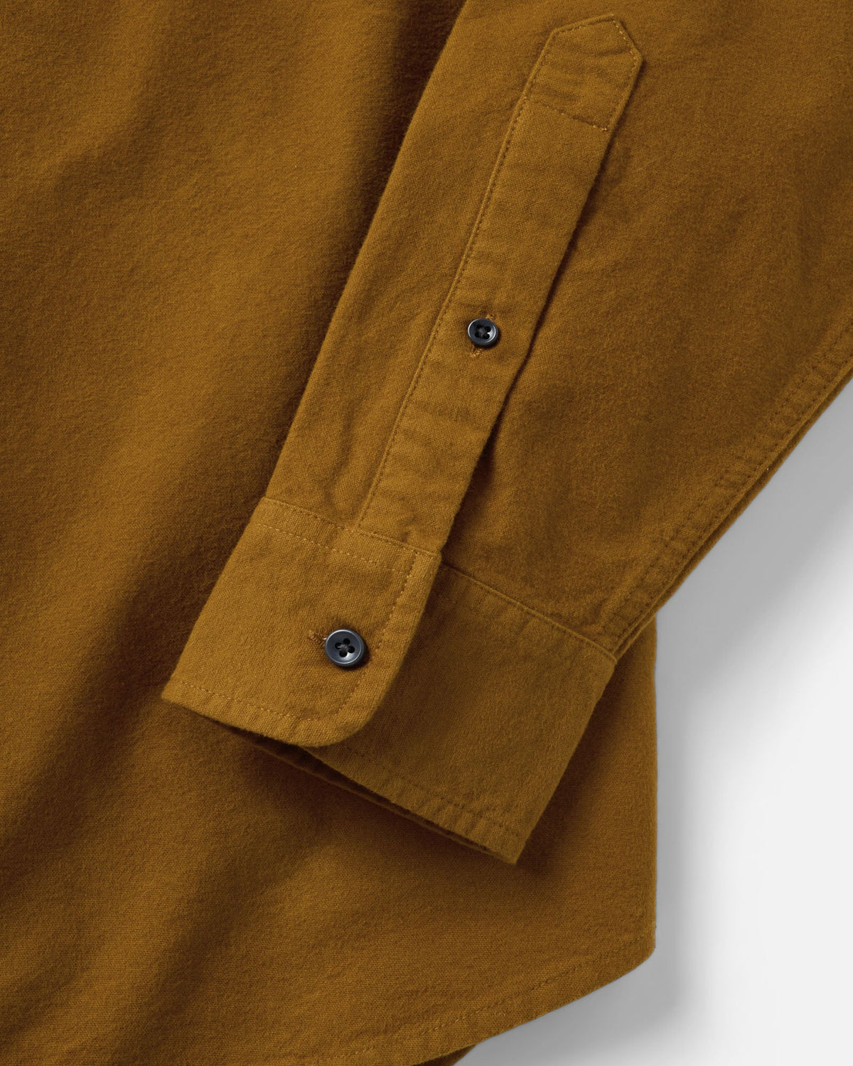 Close-up of the Yosemite Shirt in Saffron, showing the buttoned cuff, sleeve placket, and stitched hem.
