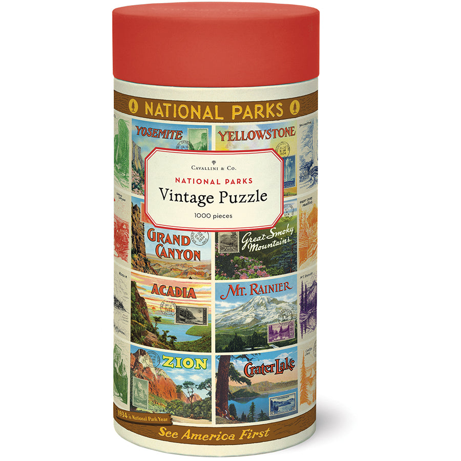 Front of the Cavallini & Co. National Parks Vintage Puzzle tube with a red lid, wrapped in colorful vintage national park postcard artwork.
